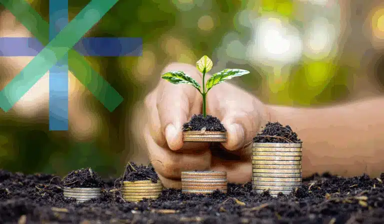 Stacked coins on soil symbolizing financial growth.